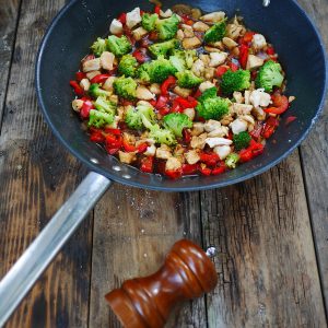 Sauté de poulet, brocoli et poivrons dans un wok.