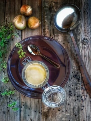 Nature morte culinaire : soupe, oignons, louche, bois