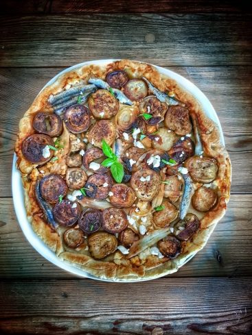 Tarte aux aubergines et anchois sur fond rustique.