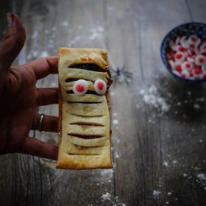 Pâtisserie momie d'Halloween, pâte feuilletée et yeux sucrés.
