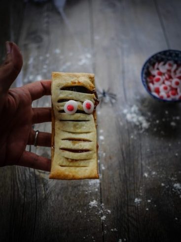 Pâtisserie momie d'Halloween, pâte feuilletée et yeux sucrés.
