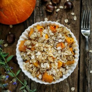 Crumble de potimarron aux châtaignes sur table en bois.