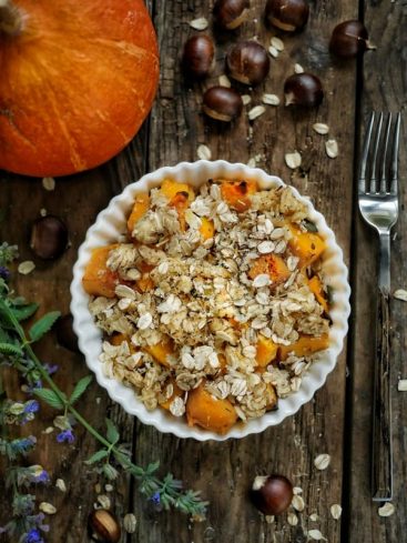 Crumble de potimarron aux châtaignes sur table en bois.