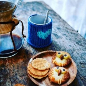 Café, gaufres et biscuits hibou sur table en bois.