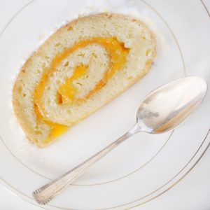 Tranche de gâteau roulé à la confiture et cuillère
