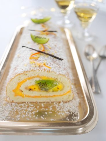 Gâteau roulé coco, kiwi, mangue sur plateau argenté.