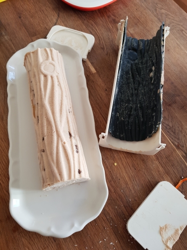 Bûche glacée et son moule sur table en bois.