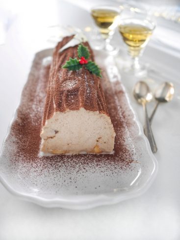 Bûche de Noël traditionnelle avec décorations festives.