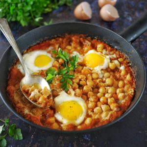 Shakshuka aux pois chiches et oeufs, persil frais.