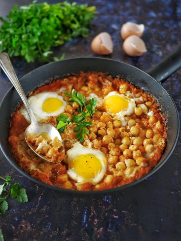 Shakshuka aux pois chiches et oeufs, persil frais.