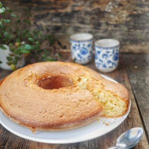 Gâteau à l'anneau, thé et cuillère sur bois.
