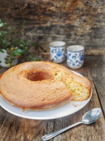Gâteau à l'anneau, thé et cuillère sur bois.