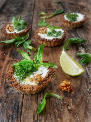 Tartelettes vegan garnies sur table en bois rustique.