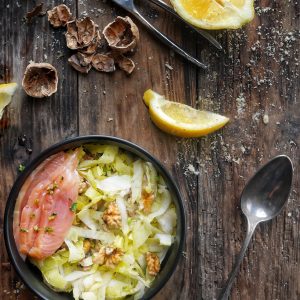 Salade de chou, saumon, noix et citron sur bois.