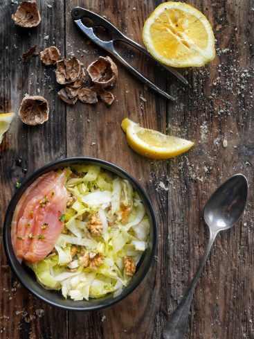 Salade de chou, saumon, noix et citron sur bois.