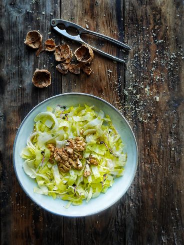 Salade d'endives et noix sur table en bois