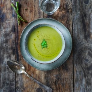 Soupe d'asperges crémeuse sur table en bois rustique.