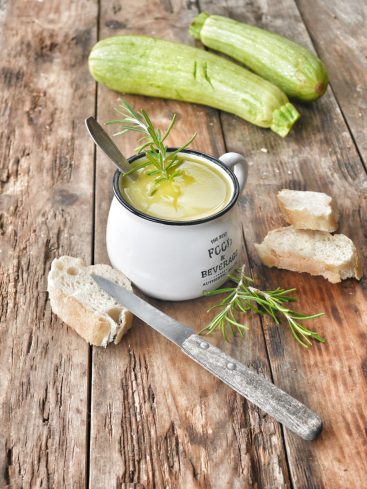 Velouté de courgette, pain et romarin sur bois rustique.