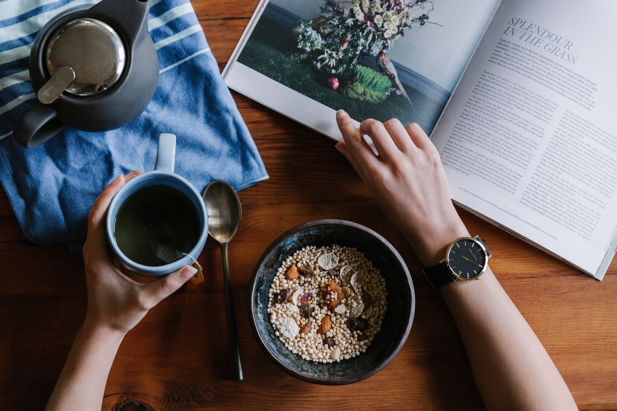 Petit-déjeuner avec thé, céréales et lecture.