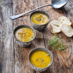 Soupe de potiron avec pain et thym sur bois.