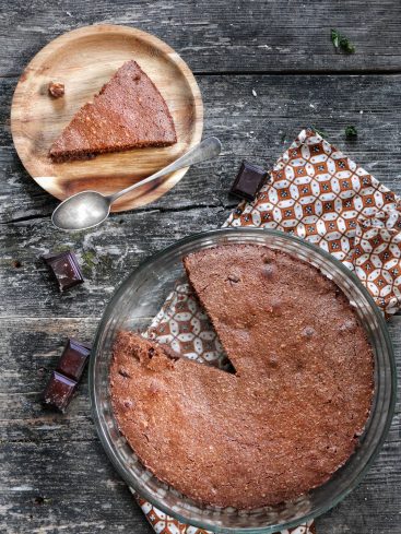 Gâteau au chocolat tranché sur table en bois rustique.