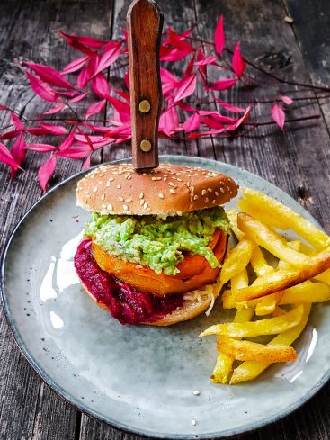 Burger végétarien avec frites sur une assiette grise.