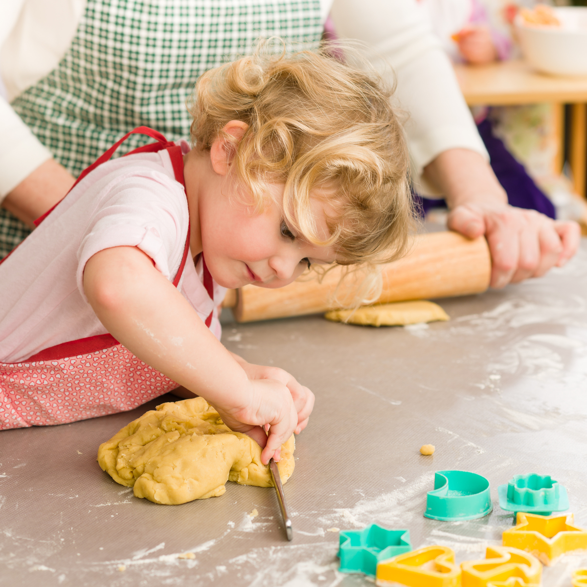 Enfant préparant des biscuits avec sa grand-mère