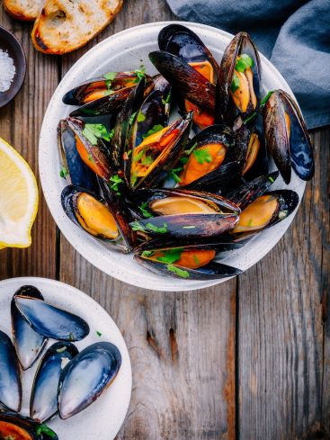 Assiette de moules marinières avec citron et pain grillé