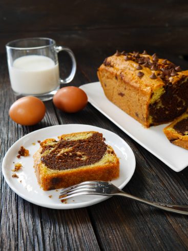 Cake marbré, lait, œufs sur table en bois
