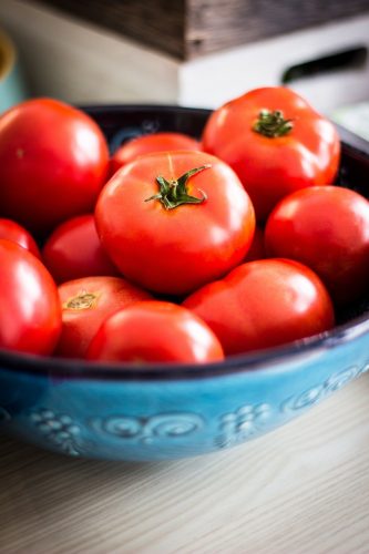 Tomates rouges fraîches dans un bol bleu décoratif.