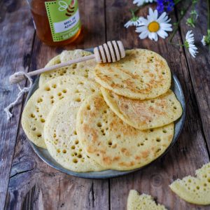 Crêpes mille trous, miel et fleurs sur bois