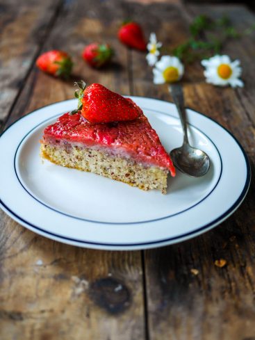 Tarte aux fraises sur assiette, fleurs et table rustique.