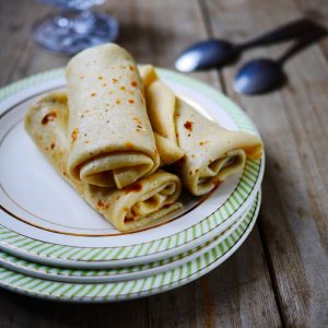 Crêpes roulées sur assiette avec fond en bois