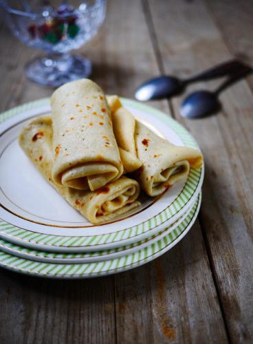 Crêpes roulées sur assiette avec fond en bois