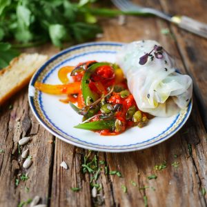 Rouleau de printemps et légumes sautés sur assiette.
