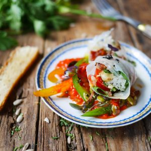 Rouleaux de printemps végétariens sur assiette rustique en bois.