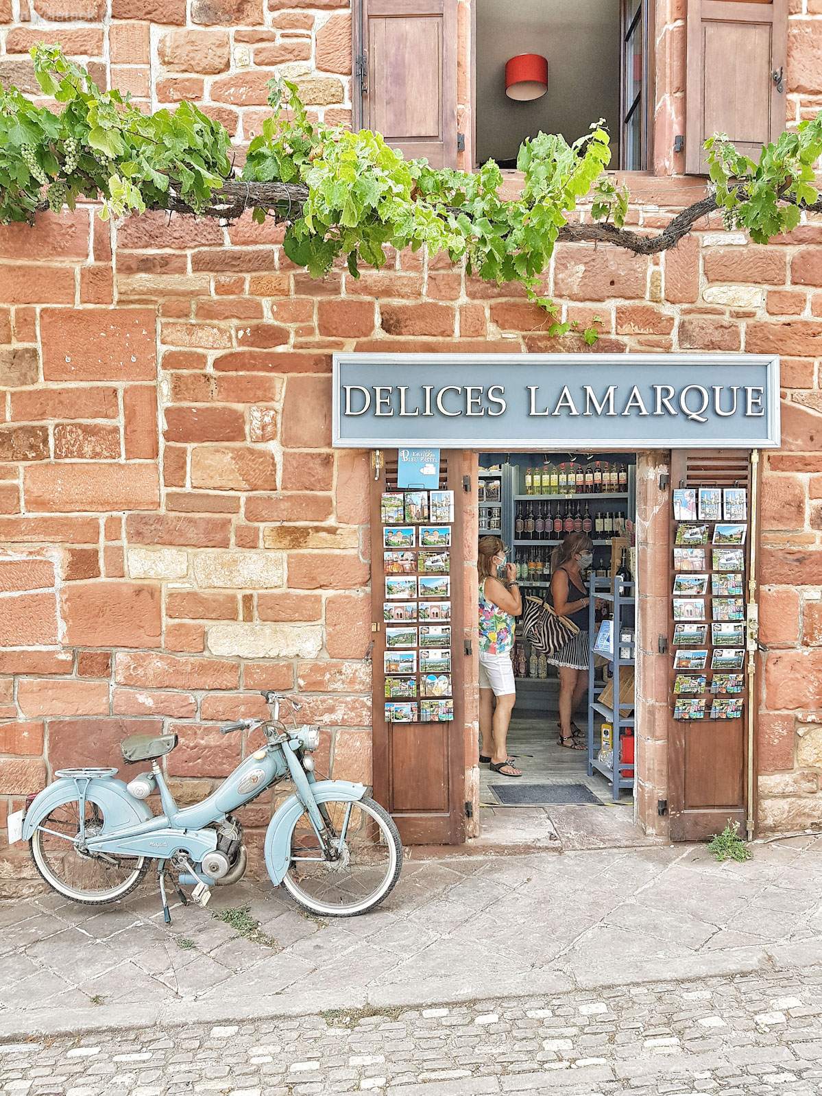 Boutique Delices Lamarque avec mobylette bleue devant.