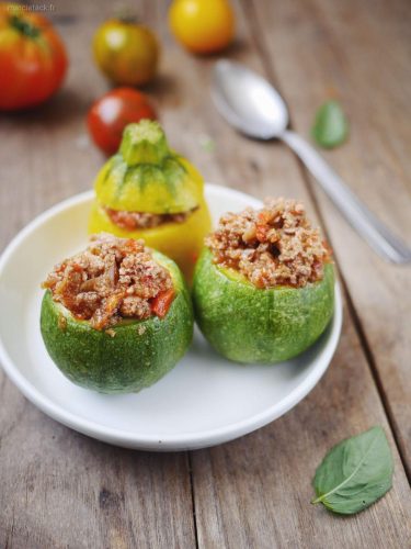 Courgettes rondes farcies à la viande sur table en bois.