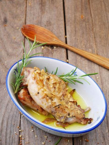 Lapin à la moutarde, romarin, sur table en bois.
