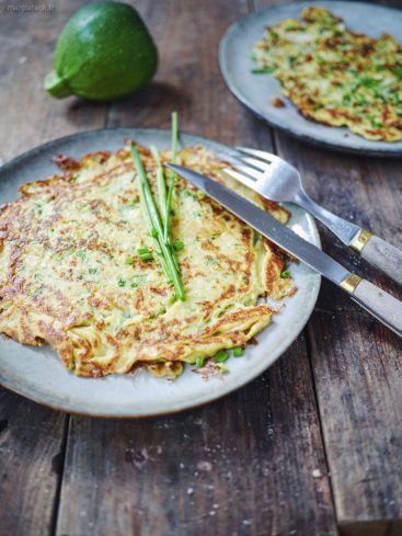Galette de courgette, ciboulette, fourchette et couteau sur bois