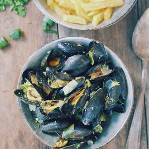 Moules marinières et frites sur table en bois