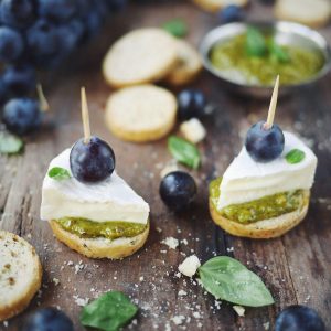 Bouchées apéritives : brie, pesto, raisin sur pain
