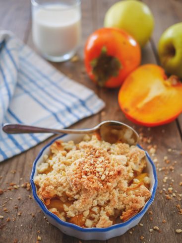 Crumble aux kakis avec pommes et lait sur table bois