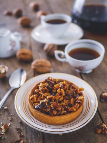 Tarte aux noix, café sur table en bois.