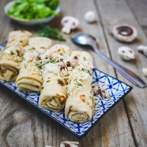 Crêpes farcies aux champignons sur assiette bleue