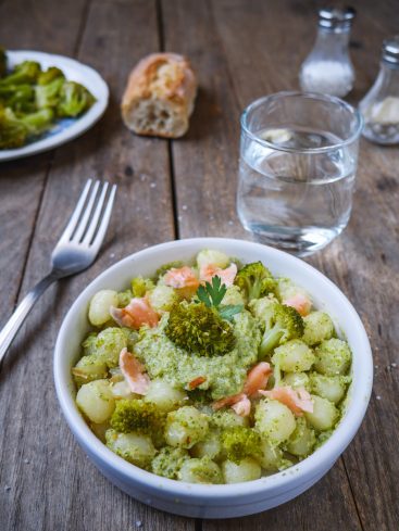 Gnocchis au brocoli et saumon, sur table bois.
