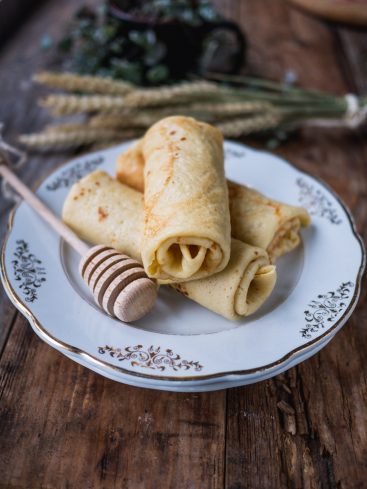 Crêpes roulées sur assiette avec miel