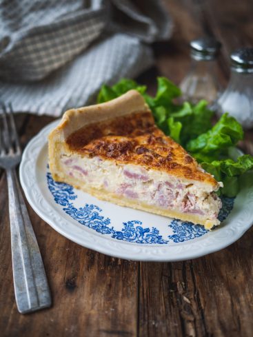 Part de quiche lorraine avec salade verte.