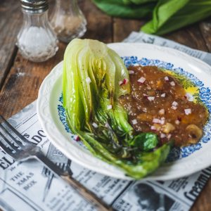 Bok choy braisé avec sauce et radis, sur table bois