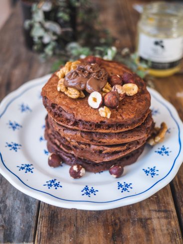 Pile de pancakes au chocolat, noix et noisettes